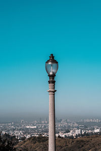 Lighting equipment in city against clear blue sky