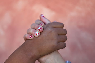Close-up of girls holding hands