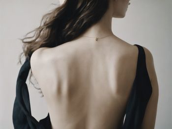 Midsection of woman standing against white background