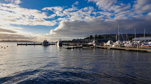 Sailboats moored on sea against sky