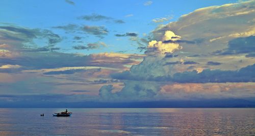 Boats in sea at sunset