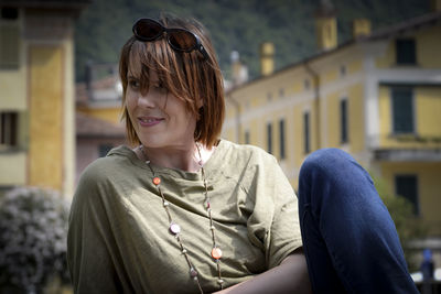 Smiling woman with short hair against buildings in town