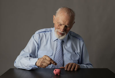 Man holding smart phone while sitting on table