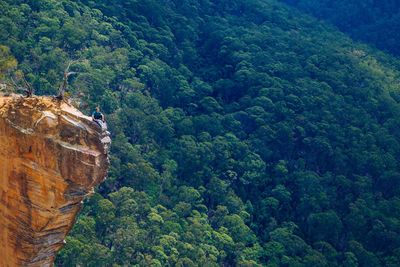 Man on cliff against trees