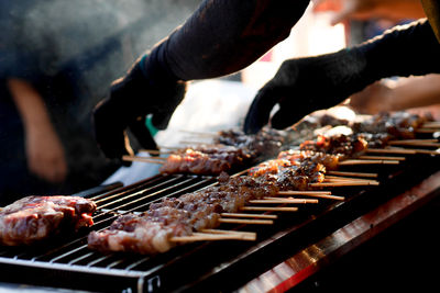 Cropped hands of man cooking food on grill