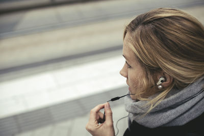 High angle view of woman using hands-free device at tram station