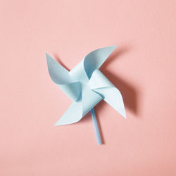 Close-up of blue pinwheel toy over pink background