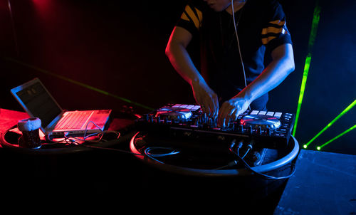 Midsection of person standing at nightclub