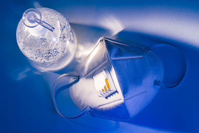 High angle view of illuminated lamp on table against blue background