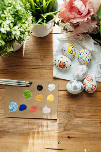 Flat lay of modern easter eggs painted. brushes and paints with flowers and plants. happy easter
