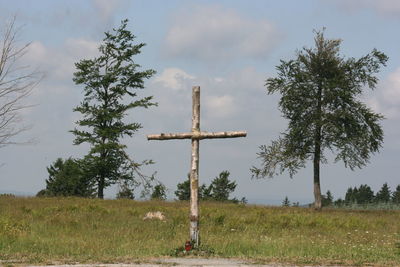 Cross on field against sky