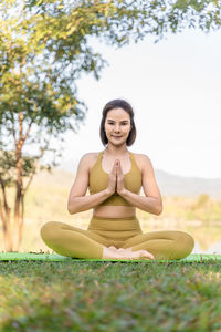 Portrait of young woman sitting on field