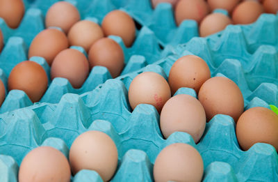 High angle view of brown eggs in carton for sale