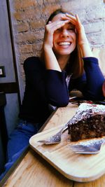 Portrait of a smiling young woman sitting on table