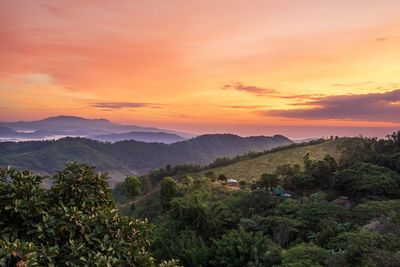 Scenic view of mountains against orange sky