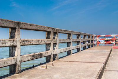 Bridge over sea against blue sky