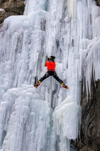 Rear view of man iceclimbing