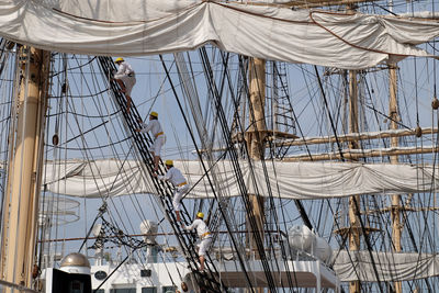 Sailboats moored in sea against sky