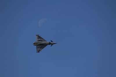 Low angle view of airplane against clear blue sky