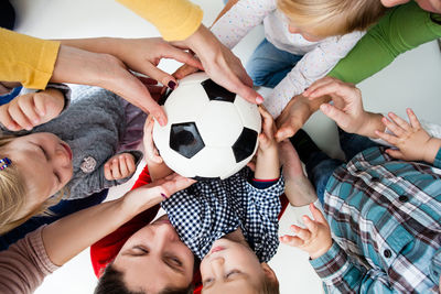 High angle view of friends playing with hands