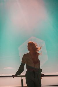 Low angle view of woman standing against sky