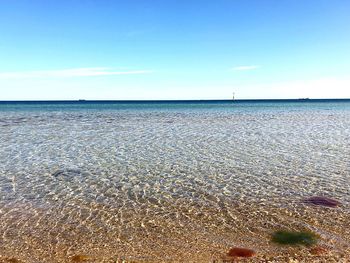 Scenic view of beach against blue sky