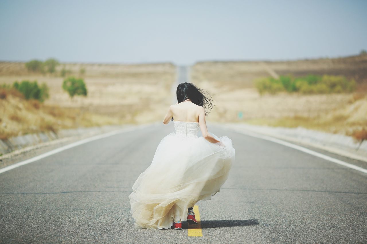 road, rear view, transportation, clear sky, focus on foreground, street, bird, full length, one animal, copy space, animal themes, one person, outdoors, day, white color, the way forward, road marking, side view, close-up, nature