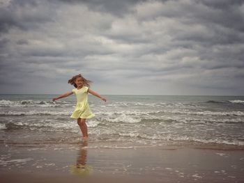 Woman standing on beach against sky