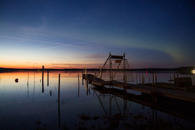 Pier in sea at sunset