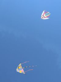 Low angle view of kite flying against blue sky