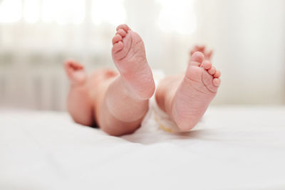 Low section of woman lying on bed at home