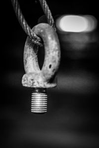 Close-up of illuminated lighting equipment hanging against black background