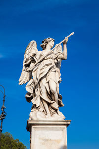 Low angle view of statue against blue sky