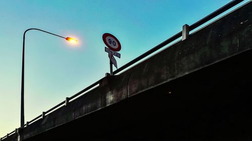 Low angle view of road sign against clear sky