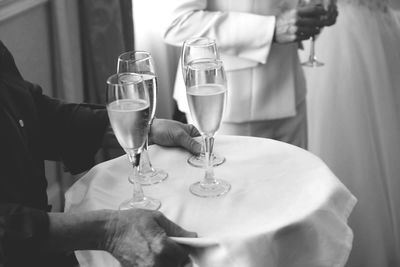 Midsection of waiter holding champagne flutes on tray