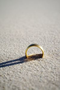 Close-up of wedding ring on beach