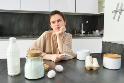 Portrait of young woman drinking coffee at home