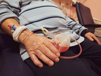 Midsection of senior man holding medical equipment