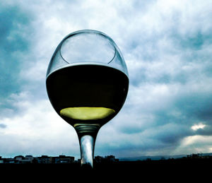 Close-up of wineglass against sky