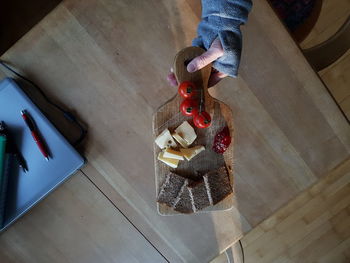 High angle view of woman holding food on table