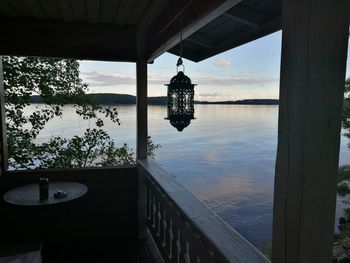 Lantern hanging by sea against sky in city