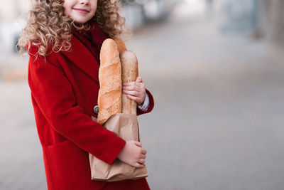 Midsection of girl holding bread outdoors