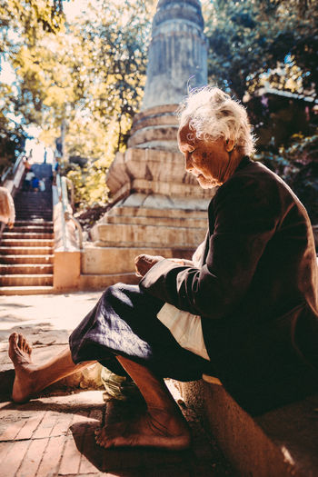 MAN SITTING BY TREE