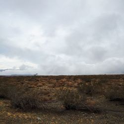 Distant view of landscape against cloudy sky