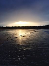Scenic view of lake against sky at sunset