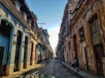 Empty road amidst buildings in city