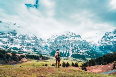 Full length of man looking at snowcapped mountain against sky