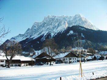 Low angle view of mountains in front of snowy field on sunny day