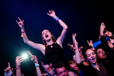 Young woman sitting on stage at night