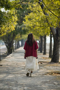 Rear view of woman walking on footpath